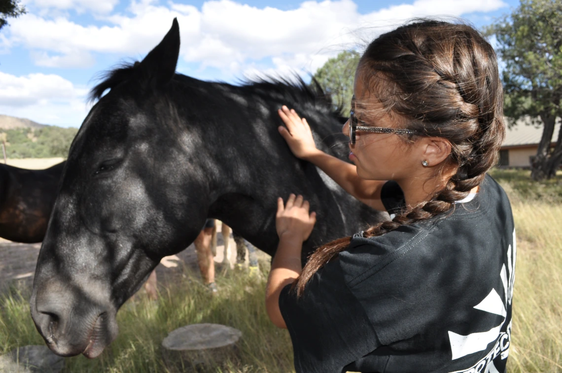 Aaliyah pets a local wild horse