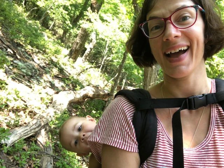 Elise backpacking with a baby on her back